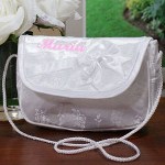 Your Embroidered Flower Girl Purse includes an ornate satin purse embroidered with your daughters name in a soft pink thread.The embroidered purse measures 5 1/4" x 7", features a satin bow and is light weight, perfect for your daughters first trip down the aisle. Includes FREE Embroidery. Personalized your Flower Girl Purse with any name ( ie. Maria )